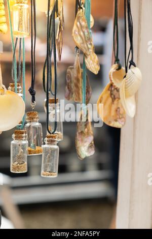 Juweliere präsentieren Meeresdekorationen auf dem Straßenmarkt. Frau, die Dekorationen auf dem lokalen Straßenmarkt in Danzig, Polen, wählt. Weibliche Touristen wählt Souvenirs im Straßenladen aus und schaut sich Farbarmbänder an. Ehrliches lokales Souvenir-Konzept. Reiseziele für Touristen Stockfoto