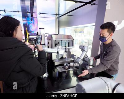 PEKING, CHINA - 17. FEBRUAR 2023 - Besucher beobachten einen intelligenten Roboter beim Kaffeekochen in Peking, China, 17. Februar 2023. Der Jidu ROBOVERSE Sanli Stockfoto