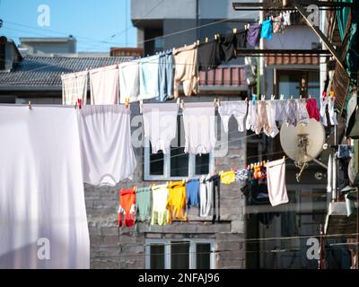 Kleidung hängt zum Trocknen an der Wäscheleine im Freien im Hof von Häusern. Wäschetrocknung in Georgia. Stockfoto