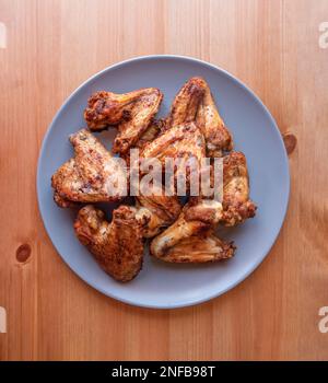 Hähnchen Popcorn, Wings and Tenders mit BBQ-Sauce auf einem Teller auf grauem Hintergrund, Draufsicht. Flach liegend, über Kopf, von oben Stockfoto