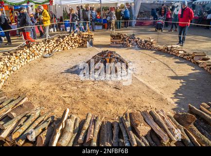 Beginnen Sie mit einem großen Lagerfeuer, das mit Holzstämmen aus dem Rauch kommt, in einem beliebten Dorffestival für typische ländliche Feiern und die Menschen in der Umgebung Stockfoto