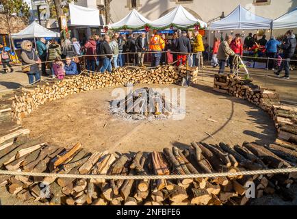 Beginnen Sie mit einem großen Lagerfeuer, das mit Holzstämmen aus dem Rauch kommt, in einem beliebten Dorffestival für typische ländliche Feiern und die Menschen in der Umgebung Stockfoto