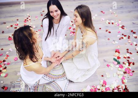 Women's Recovery Group. Verschiedene Mädchen Lächeln Hände Halten Sitzen In Circle Indoor. Selektiver Fokus. Frauen umarmen sich in einem Frauenkreis Stockfoto