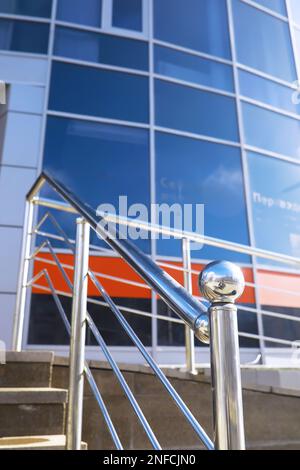Geländer aus Glas und Edelstahl. Treppe im modernen Interieur. Glasgeländer. Niedriger Winkel Blick auf Treppen, die in Richtung eines modernen Gebäudes führen. Stockfoto