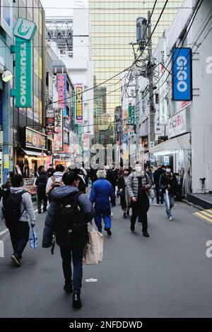 Menschenmassen, die durch eine Seitenstraße in Akihabara in Tokio, Japan, wandern. Stockfoto