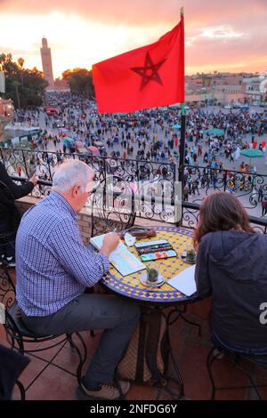 MARRAKESCH, MAROKKO - 20. FEBRUAR 2022: Künstler malt Jemaa el-Fnaa Marktplatz der Stadt Marrakesch, Marokko. Der Platz ist als UNESCO Masterpie gelistet Stockfoto