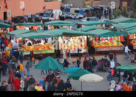 MARRAKESCH, MAROKKO - 20. FEBRUAR 2022: Menschen besuchen den Jamaa el-Fnaa-Markt der Stadt Marrakesch, Marokko. Der Platz ist als UNESCO-Masterpiec gelistet Stockfoto
