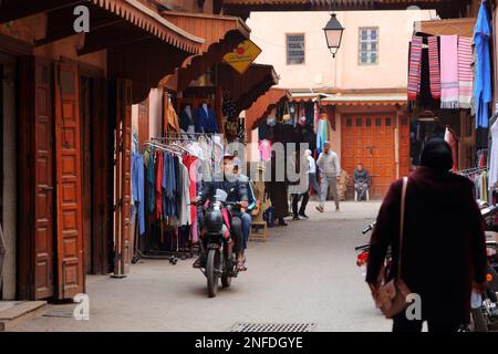 MARRAKESCH, MAROKKO - 20. FEBRUAR 2022: Menschen besuchen Straßen der Medina (Altstadt) der Stadt Marrakesch, Marokko. Das historische Medina-Viertel ist ein UNESCO-Weltkulturerbe Stockfoto