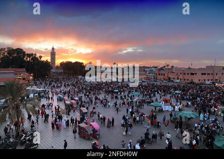 MARRAKESCH, MAROKKO - 20. FEBRUAR 2022: Menschen besuchen den Markt auf dem Jemaa el-Fnaa-Platz in Marrakesch, Marokko. Der Platz ist als UNESCO-Masterpiec gelistet Stockfoto