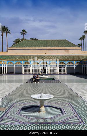 MARRAKESCH, MAROKKO - 20. FEBRUAR 2022: Touristen besuchen den großen Hof des Bahia-Palastes in Marrakesch. Das historische Medina-Viertel von Marrakesch gehört zum UNESCO-Weltkulturerbe Stockfoto