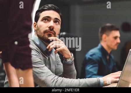 Ein weißer Mann, der eine unbekannte Kollegin ansieht und zuhört, was sie zu sagen hat Stockfoto