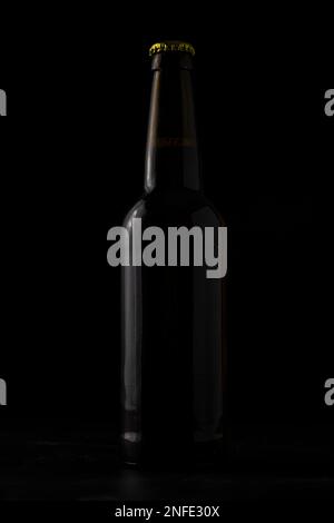 Eine Flasche Bier auf schwarzem Hintergrund. Stockfoto