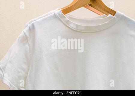 Weiße Baumwolle-T-Shirts an den Kleiderbügeln aus der Nahaufnahme. Platz für Text Stockfoto
