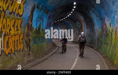 Mann Walking und Radfahrer im Colinton Eisenbahntunnel, gemalt vom Künstler Chris Rutterford, Edinburgh, Schottland, Großbritannien Stockfoto