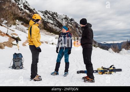 Gruppe von Bergsteigern an einem bewölkten Tag in den schneebedeckten Bergen Stockfoto