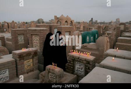 Relatives light candles and recite verses of the Holy Quran as they pay ...