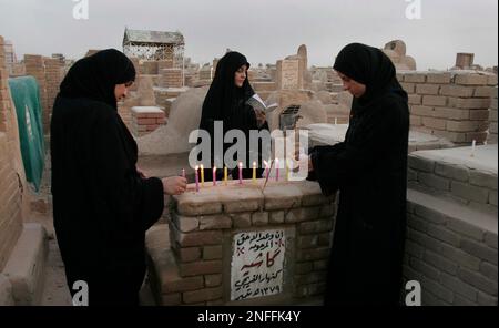 Relatives light candles and recite verses of the Holy Quran as they pay ...