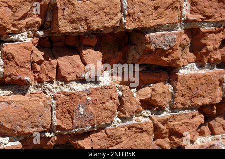 Alte, englische Bindung verlegte eine Ziegelmauer in schlechtem, erodiertem Zustand. Stockfoto