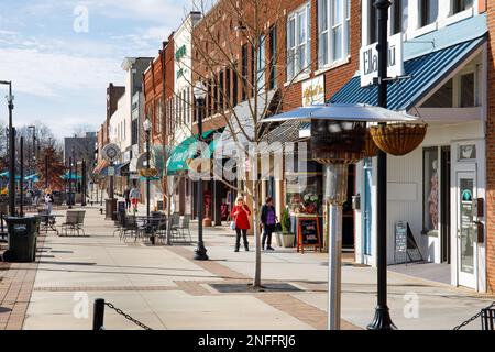 HICKORY, NC, USA-14. FEBRUAR 2023: Downtown plaza mit Outdoor-Restaurants, Shoppern, Schaufenstern, an sonnigen Wintertagen. Stockfoto