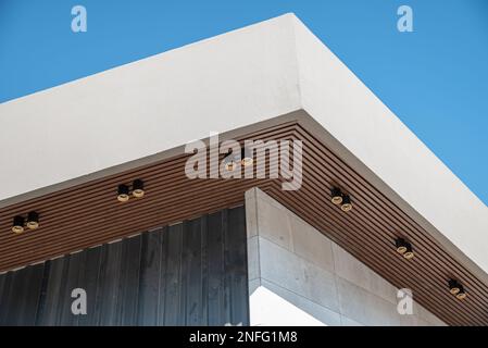 PVC-Deckenplatte mit holzartiger Vinylverkleidung und moderner Beleuchtung Stockfoto