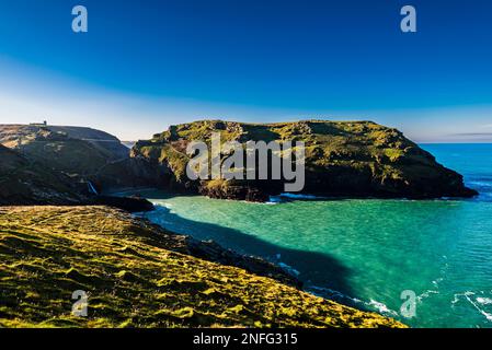 Tintagel Island und Fußgängerbrücke mit Blick auf Tintagel Haven von Barras Nose, Tintagel, Cornwall, Großbritannien Stockfoto