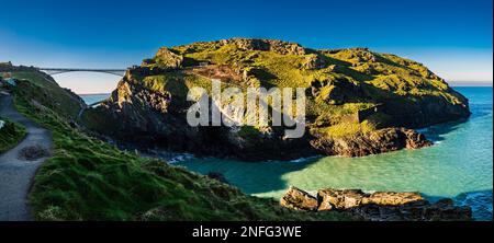 Panoramablick auf Tintagel Island und Fußgängerbrücke mit Blick auf Tintagel Haven, Tintagel, Cornwall, Großbritannien Stockfoto