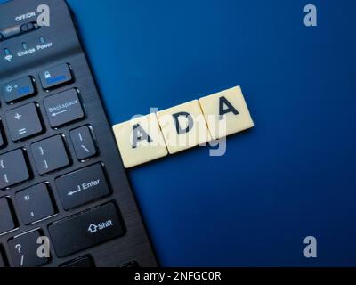 Spielzeugwort und Tastatur mit dem Wort ADA auf blauem Hintergrund. Geschäftskonzept. Stockfoto