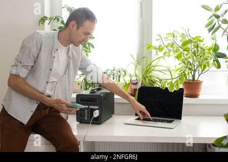 Ein Mann verwendet eine tragbare Ladestation Stockfoto