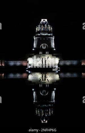 Nachtaufnahme des Denkmals für die Schlacht der Nationen 1813 in Leipzig, Reflexion im Wasser, vertikaler Schuss, Wahrzeichen und Gedenkfeier Stockfoto