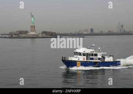Das NYPD New York Police Department Boot patrouilliert die Gewässer vor der Freiheitsstatue Stockfoto