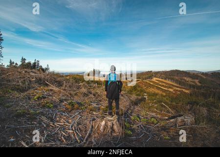 Reisende mit einem blauen Rucksack auf dem Rücken wandern zu seinen unvergesslichen Erlebnissen in den Beskydy-Bergen, Tschechische republik. Die Morgensonne leuchtet Stockfoto