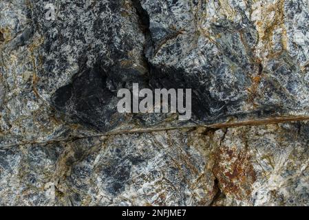 Diese Nahaufnahme von Felsen zeigt die raue, natürliche Schönheit der geologischen Formationen. Die rauen Oberflächen und Strukturen der Felsen sind Promi Stockfoto