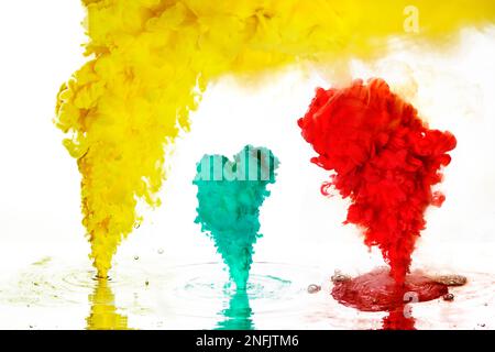 Gelbe, zyanblaue und rote Tinte in Wasser wie ein Rauch in der Luft. Stockfoto