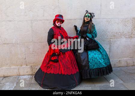 Karnevalsbesucher, die im Februar während des Karnevals 2023 in Venedig in prächtigen Kostümen und Masken gekleidet waren, am Markusplatz in Venedig, Italien Stockfoto