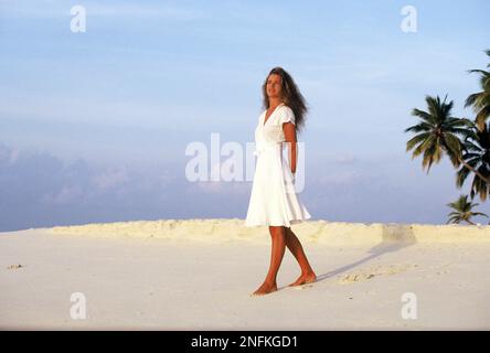 Malediven. Junge Frau steht am tropischen Strand. Stockfoto