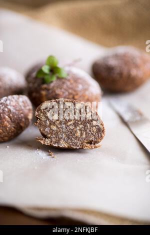 Schokoladen-Süßkuchen aus pürierten Keksen mit Zusatzstoffen auf Backpapier. Stockfoto