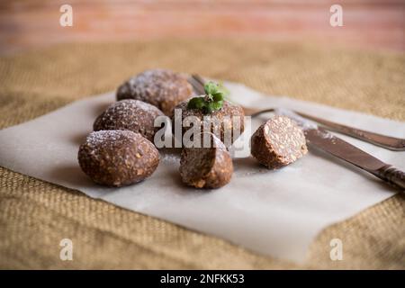 Schokoladen-Süßkuchen aus pürierten Keksen mit Zusatzstoffen auf Backpapier. Stockfoto