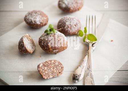 Schokoladen-Süßkuchen aus pürierten Keksen mit Zusatzstoffen auf Backpapier. Stockfoto