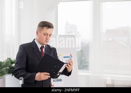 Ein Mann im Büro durchsucht Dokumente. Büroangestellter Stockfoto