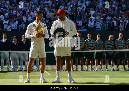 menÕs Singles Champion Novak Djokovic mit seiner Gewinnertrophäe und dem Nächstplatzierten Nick Kyrgios bei den Wimbledon Championships 2022. Im All England Stockfoto