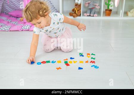 Das Kind lernt Zahlen und Buchstaben. Selektiver Fokus. Kleiner. Stockfoto