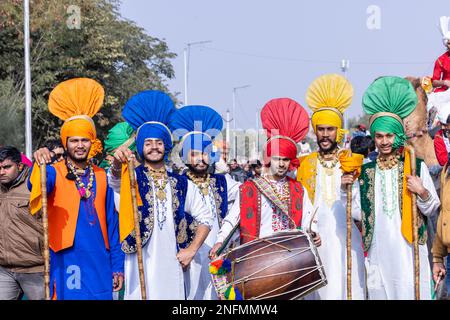 Punjabi Bhangra, Porträt des jungen sikh männlich in traditionellem punjabi farbenfrohem Kleid und Turban mit Bhangra-Tanz mit Lächeln im Kamelfestival. Stockfoto