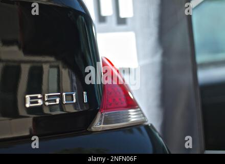 BMW 850i-Bremsleuchte in Schwarz-Metallic-Ausführung mit Bokeh-Hintergrund für Tiefenschärfe Stockfoto