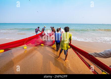 Fischer, die ein Netz am Strand von Tangalle an der Südküste Sri Lankas einziehen Stockfoto