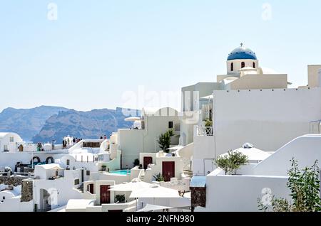 Oía, Santorin, Griechenland; 22. Juni 2022: Blick auf die weißen Häuser und gepflasterten Straßen in den Kykladen. Stadt am südlichen Ägäischen Meer Stockfoto
