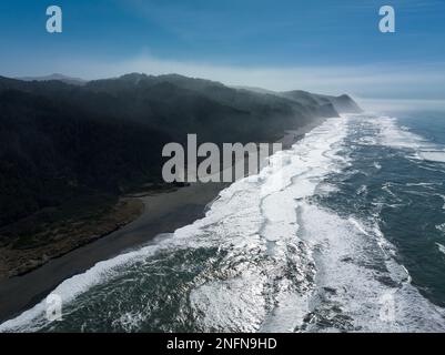 Am Nachmittag scheint das Sonnenlicht auf den Pazifik, der sich am Gold Beach entlang der malerischen Südküste von Oregon erstreckt. Diese Gegend liegt am Highway 101. Stockfoto