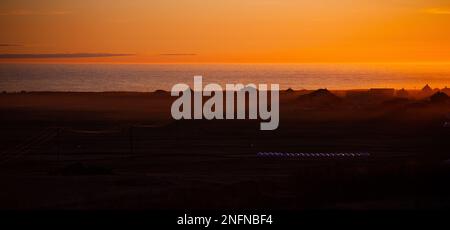 Ein orangefarbener Sonnenuntergang am Unstad Beach in Lofoten, Norwegen Stockfoto