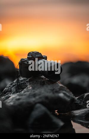 Eine vertikale Aufnahme der professionellen A7 Kamera von sony auf dem Felsen bei Sonnenuntergang Stockfoto