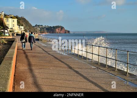 Ein Paar, das am Meer entlang in Teignmouth, South Devon, spaziert. Stockfoto