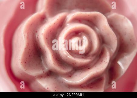 Draufsicht auf eine rosafarbene Schokolade in Form einer Rose mit Himbeeren Stockfoto